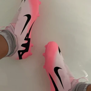 Nike fotbollsskor i rosa och svart - Snygga fotbollsskor från Nike, perfekta för fotbollsplanen. De är bara använda en gång men fortfarande är i helt nytt skick. Säljer pga att e är för små 🩷Pris kan diskuteras 🩷
