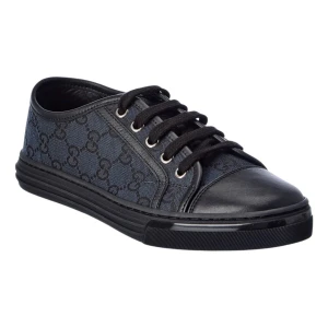 Svarta sneakers från Gucci - Snygga svarta sneakers från Gucci med monogrammönster. Skorna har en kombination av skinn och textil med snörning framtill. Perfekta för en stilren look. Använda endast ett par gånger