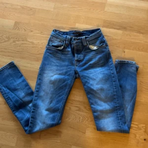 Blå jeans från Nudie Jeans - Snygga blå jeans från Nudie Jeans med en klassisk femficksdesign. De har en normal passform och är tillverkade i slitstarkt denim. Perfekta för en avslappnad stil.
