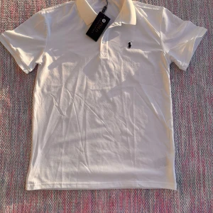 Polo Raulph Lauren shirt - ✔ Märke: Polo Ralph Lauren ✔ Modell: Pikétröja ✔ Färg: Vit ✔ Storlek: Medium (M) ✔ Material: Högkvalitativ bomullsmesh – andas och är bekväm ✔ Passform: Allt från 165-183cm 60-80kg beroende på hur man vill den ska sitta.