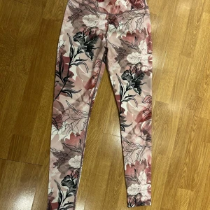 Nya träningstights SOC rosa och svart, storlek 158-164 - Nya träningstights med TCS airflow från Stadium. De har ett blommigt mönster i rosa och svart.