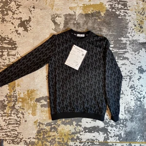 Tröja - Säljer en snygg svart tröja med ett stilrent mönster i grått. Tröjan är i nytt skick med etiketterna kvar. Materialet känns lyxigt och bekvämt. Perfekt för både vardag och fest! 🖤.