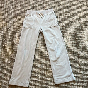 Beige mjukisbyxor från Juicy Couture - Snygga mjukisbyxor från Juicy Couture i stolek XS passar på längden 150-155cm. Bra skick men har tappat metall skydden på snörena.🩷Köpta för 1100kr säljer lågt pga snörena. Pris kan diskuteras🩷