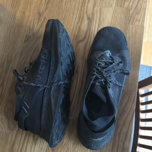 Svarta sneakers från Nike - Snygga svarta sneakers från Nike med robust sula och snörning. Perfekta för en aktiv livsstil med en stilren design. Skorna har en slitstark yttersula och är gjorda i syntetmaterial.