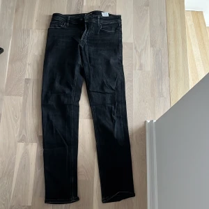 Jack and jobes jeans (grabb) - Snygga svarta jeansbyxor med en klassisk femficksdesign. De har en rak passform och är perfekta för en stilren look. Byxorna har en dragkedja och knapp framtill.