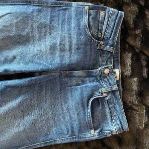 Blå jeansbyxor - Snygga blå jeansbyxor med klassisk femficksdesign och knappgylf. Perfekta för en avslappnad stil. De har en normal passform och är tillverkade i slitstarkt denim.