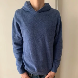 Blå cashmere hoddie  - Säljer en stilren blå hoodie från Ahlquist Clothing i storlek M. Tröjan har en klassisk design med långa ärmar och en bekväm huva. Perfekt för kyligare dagar. Hör av mig er vid frågor!