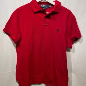 Snygg röd RalphLauren pike i storlek M. Modellen är 180cm.