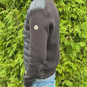 Moncler cardigan - Säljer en snygg svart cardigan från Moncler i storlek L säljer då den är för liten! Den är i ny skick 