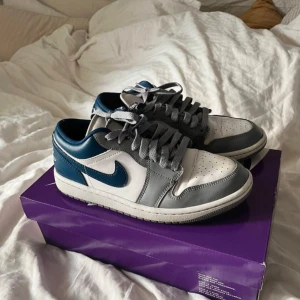 Nike SB Dunk Low - Säljer ett par snygga Nike SB Dunk Low sneakers i blått och grått. De har en klassisk design med snörning och en vit sula. Perfekta för vardagsbruk eller en avslappnad stil.   💗 Nypris: 1796kr 💗 Tillkommer extra snören + orginalkvitto   Skorna är i bra skick men lite slitage vid snörning (se bild). Har även gulnat vid framsida sko - har ej försökt få bort men kan tänka mig att de säkert går. Pris kan diskuteras! 🩷