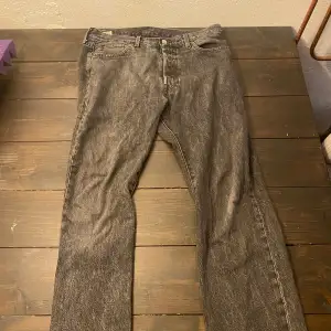 Säljer ett par grå Levi's jeans i bra skick. De har en klassisk femficksdesign med knappgylf och är i en straight fit. Storlek W33 L32