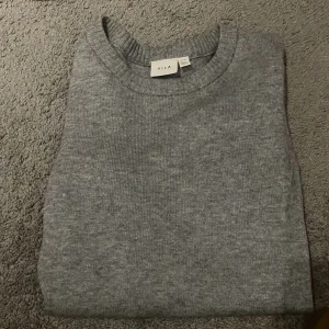 Grå stickad tröja från Vila - Säljer en mysig grå stickad tröja från Vila i storlek Xs. Perfekt för kyliga dagar med sin mjuka och bekväma passform. Tröjan har långa ärmar och ribbade kanter vid ärmslut och nederkant. Passar både till vardags och lite finare tillfällen. 🩶helt ny