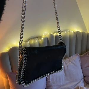 Svart axelväska med kedjedetaljer - Stor Tiamo väska som får plats med mycket. Kan användas med både kort och långt band. Superbra skick! 🖤