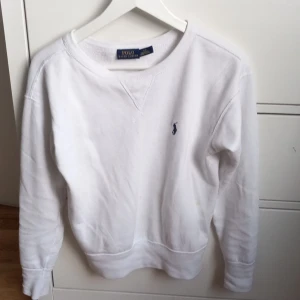 Vit tröja från Polo Ralph Lauren - Säljer en klassisk vit tröja från Polo Ralph Lauren i mycket bra skick. Tröjan har en liten broderad logga på bröstet och är tillverkad i mjukt bomullsmaterial. Perfekt för både vardag och festliga tillfällen. Passar till allt! 🤍
