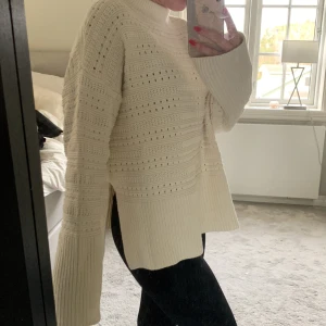 Vit stickad tröja från Samsøe Samsøe - Superfin vit stickad tröja från Samsøe Samsøe. Den har en mysig och luftig design med ett snyggt hålmönster och slits på båda sidorna. Perfekt för kyliga dagar med sin höga krage och långa ärmar. Passar både till vardags och lite finare tillfällen. Jag bär tröjan i XXS och har vanligtvis XS. Tröjan är stor i storlek. Nypris 2400
