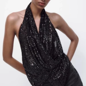 Nyårs topp - Snygg svart halterneck topp med glittriga paljetter, perfekt för fest. Toppen har en öppen rygg med knytning. Sååå snygg, perfekt till nyår. Aldrig använd med lappen kvar. Slutsåld på hemsidan