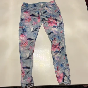 Blommiga leggings från SOC - Säljer ett par blommiga leggings från SOC i pastellfärger. Perfekta för träning eller en avslappnad dag. De har en tight passform och är gjorda i ett mjukt och stretchigt material. Superbekväma och stiliga!