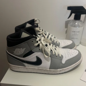 Nike Air Jordans i grått och vitt - Säljer ett par Nike Air Jordans i grått och vitt. De har en klassisk design med snörning och den ikoniska swoosh-loggan i svart. Skorna är i mycket bra skick och passar perfekt för både vardag och fest. Rengörs innan köp. Storlek 43 