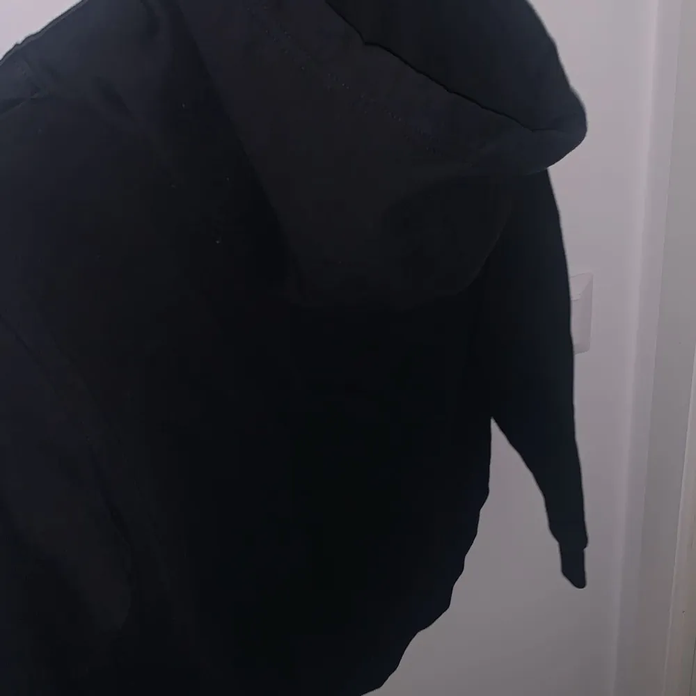Säljer en stilren svart hoodie från Calvin Klein. Den har en klassisk passform med justerbar huva och det ikoniska Calvin Klein-logotypen tryckt på framsidan. Perfekt för en avslappnad look eller att mysa i hemma. Passar till alla säsonger!. Neuletakit & Villapaidat.