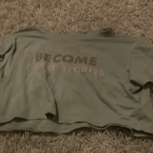 Grön t-shirt med text - Säljer en grön t-shirt från 157 i storlek M. Den har en cool text på framsidan som säger 'BECOME GREAT STORIES'. Perfekt för en avslappnad stil. T-shirten är i bra skick och passar perfekt till vardags.