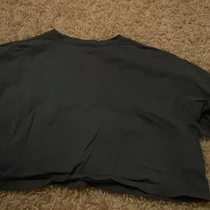 Mörkgrön t-shirt från Shein - Säljer en mörkgrön t-shirt från Shein i bra skick. Den är kortärmad och har en enkel, stilren design. Perfekt för vardagsbruk eller att matcha med en snygg jacka. Passar bra till både jeans och kjol!