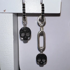 Svarta dödskalleörhängen från L8H - Coola örhängen med svarta dödskallar och en unik asymetrik kedjedetalj. De är i svart och silver. Jättebra skick. Bara att skriva om du har frågor. Köpta för 1200kr🥰🥰Om ni skulle vara intresserade i ett av örhängena även då bara att höra av sig!!