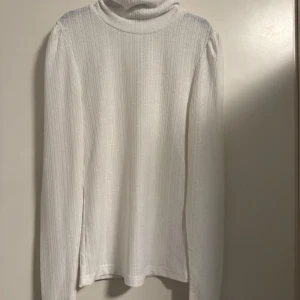 Vit ribbad polotröja från Rut & Circle - Säljer en stilren vit polotröja från Rut & Circle i storlek S. Tröjan är ribbad och har långa ärmar, perfekt för kyligare dagar. Den är i mycket bra skick och passar både till vardags och fest. Ett måste i garderoben! 🤍