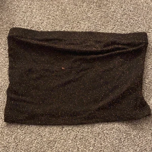 Svart glittrig topp - Säljer en superfin svart topp med glittriga detaljer. Perfekt för festliga tillfällen! Toppen är stretchig och bekväm, vilket gör den lätt att bära hela kvällen 🖤✨