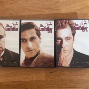The Godfather DVD Box Set - Säljer en komplett DVD-box med The Godfather-trilogin. Boxen innehåller alla tre filmerna i serien, med ikoniska omslag i svart och vitt. Perfekt för filmälskare som vill ha en klassisk maffiaepos i sin samling. Alla skivor är i bra skick och kommer i sina originalfodral. Vi diskuterar priset 