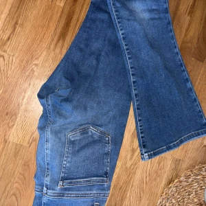 Blå jeansbyxor - Säljer ett par mörkblå low flare jeans från bikbok💗 nypris 699kr, bra skick💗 Säljes då dom är för korta för mig💗strl XS x 31