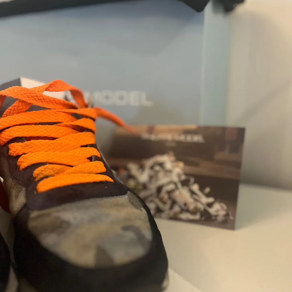 Philippe Model sneakers i camouflage och orange detaljer (Går att byta skosnören om du ej gillar dessa) väldigt unika och snygga, Säljer i befintligt skick, vid frågor och funderingar tveka ej, dustbag och box medföljer!. Skor.