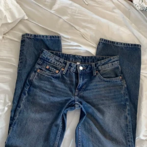 Blå jeans från Weekday - Säljer ett par snygga blå jeans från Weekday i modellen Arrow Low Straight. De är i bra skick och har en klassisk femficksdesign med knapp och dragkedja.💘skriv för fler bilder!