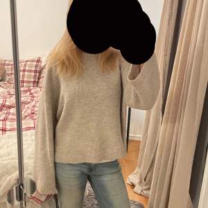 Mysig beige stickad tröja i bra skick. Perfekt för höst och vinter med sin varma och bekväma passform. Tröjan har långa ärmar och ribbade kanter som ger en stilren look. Passar perfekt till jeans för en avslappnad stil.