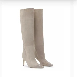 Beige stövlar med klack - Snygga beige/grå stövlar i mocka från Custommade med spetsig tå och hög klack. Helt ny och oanvända, säljer pga fel storlek för mig. Storleken är 36 men skulle säga att det är som en 37. Köpta på Thernlunds i Stockholm för 4399 kr och säljer för 2900 kr men pris kan diskuteras.  Perfekta för höst och vinter, dessa stövlar ger en elegant touch till vilken outfit som helst. De är i mycket bra skick, helt nya och redo att bäras till både vardag och fest. Kartong och allt medföljs. 