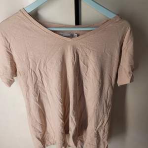 Säljer en enkel och stilren rosa t-shirt från 157 i storlek M. Den har en v-ringad hals och korta ärmar, perfekt för vardagsbruk. Materialet känns mjukt och bekvämt, idealiskt för både vår och sommar. Passar bra till jeans eller kjol för en avslappnad look.