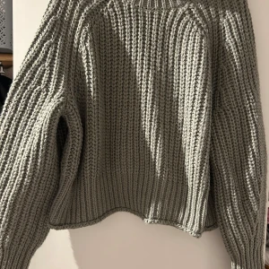 Grå stickad polotröja - Säljer en supermysig grå stickad polotröja. Perfekt för kyliga dagar med sin höga krage och långa ärmar. Tröjan har en loose fit och är ribbad för extra stilpoäng. Passar perfekt till både jeans och kjol. Ett måste i garderoben för höst och vinter!