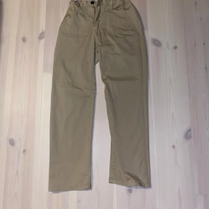 Beige byxor från Kappahl - Säljer ett par bekväma beige byxor från Kappahl i storlek 164. De har en elastisk midja och är perfekta för vardagsbruk. Byxorna är i bra skick och passar till både avslappnade och mer uppklädda tillfällen.