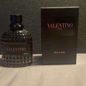 Valentino Uomo Born in Roma Eau de Toilette - Säljer en lyxig Valentino Uomo Born in Roma Eau de Toilette. Flaskan är svart med ett coolt nitat mönster och rymmer 100 ml. Perfekt för den som vill ha en elegant och modern doft. Kommer i en snygg svart kartong. Perfekt present eller för att unna sig själv! 🌟