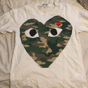 CDG T-shirt  - Säljer en vit CDG T-shirt då den är lite för liten, den är i storleken S men passar XS.  T-shirten är i mycket bra skick och använd väldigt sparsamt, passar perfekt till både vardag och fest.