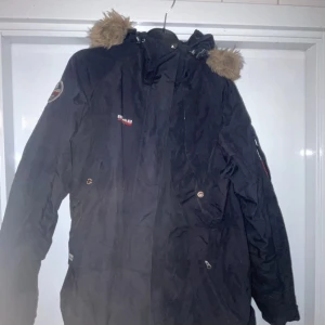 Svart vinterjacka från 8848 Altitude med tillagt päls - Säljer en svart vinterjacka från 8848 Altitude i bra skick. Jackan har en mysig pälsfodrad huva och är perfekt för kalla dagar. Den har en snygg broderad logga på ärmen och många praktiska fickor. Perfekt för vinterns äventyr! ❄️