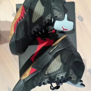 Air Jordan 5 Retro Gore-Tex Off-Noir - Säljer ett par Air Jordan 5 Retro Gore-Tex i färgen Off-Noir. Skorna har en cool svart design med röda detaljer och en unik sula. De är perfekta för både samlare och sneakerheads. Skorna är i bra skick och kommer med originalkartong. Perfekta för höst och vinter!