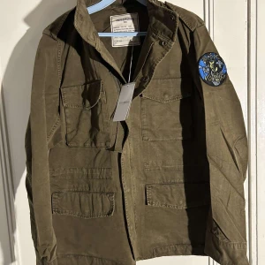 Field jacka zadig Voltaire - Tja, jag säljer nu denna feta field jackan ifrån Zadig Voltaire, den e helt ny med tags kvar. Priset är inte fast och kan gå ner i pris, snabb affär uppskattas. Nypris≈ 4000 mitt pris 1399. Vid frågor eller funderingar så är det bara att höra av er. Den har spännen inuti så man kan justera den till en perfekt passform, man kan även väckla ut en luva. Byte= intressant. MVH