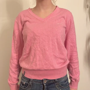 Rosa tröja från Sebago - Säljer en superfin rosa tröja från Sebago i storlek S. Den har en v-ringad hals och långa ärmar, perfekt för både vår, vinter och höst. Tröjan är i bra skick och gjord av mjukt material som känns skönt mot huden. Passar perfekt till jeans för en avslappnad look!