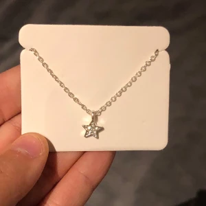 Silverhalsband med stjärnhänge - Säljer ett superfint silver halsband med en stjärn berlock har aldrig använt så gott som ny.Är i början ifrån glitter.