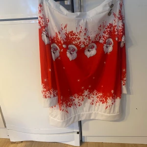Röd och vit jultröja med tomtemotiv - Säljer en festlig jultröja i rött och vitt med tomtemotiv och snöflingor. Tröjan har en lös passform och trekvartsärmar, perfekt för julfirandet. Den är i bra skick och redo att sprida julstämning! 🎅❄️