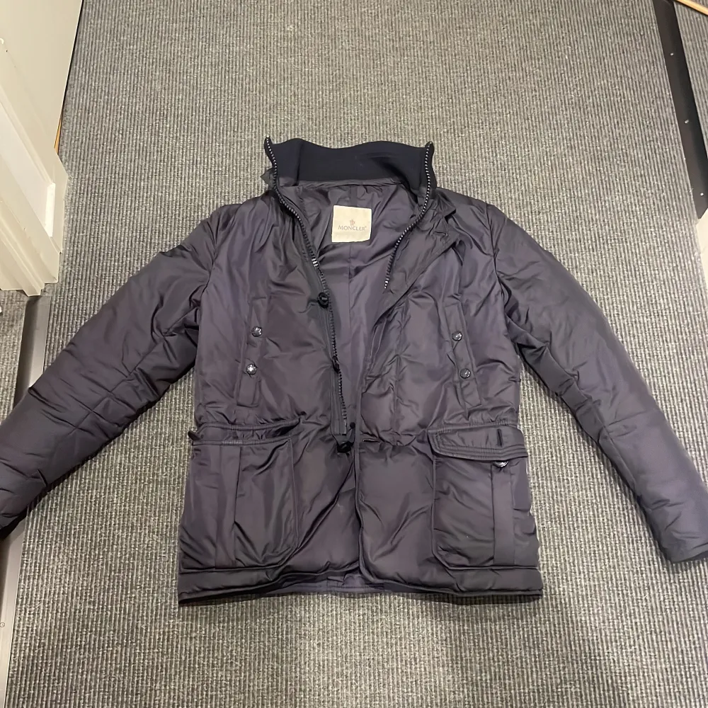Moncler jacka, storlek 2 vilket motsvarar s/m, färgen är mörkblå och skicket är 9/10 knappt använd! NO BADGE. Perfekt inför vintern o de kallare tiderna! priset är inte hugget i sten. kom privat för fler frågor eller funderingar!🙌 Tar även emot byten!. Takit.