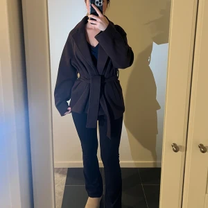 Mörk Brun kappa med bälte från Gina tricot  - Säljer en snygg mörk brun kort kappa i mycket bra skick. Den har ett bälte i midjan för en fin passform. Perfekt för höst och vinter. Kappan är från Gina tricot i storlek xs men passar även s❤️