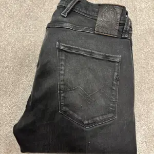 Säljer dessa mörgråa Replay Anbass Jeans (slimfit). Jeansen är snyggt urtvättade och är i bra skick. Size 28/32. Skriv vid funderingar!