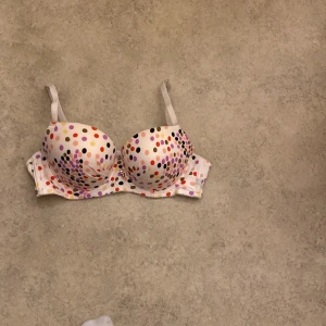 Prickig bh från Binnys - Säljer en söt bh från Binnys med ett färgglatt prickigt mönster. Den har justerbara axelband och är i mycket bra skick. Perfekt för att liva upp vardagsgarderoben! 🌈