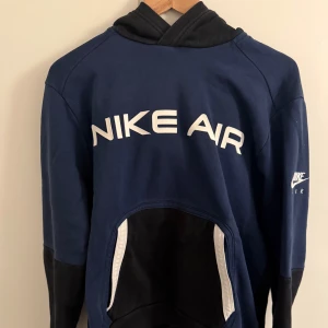Mörkblå dress från Nike Air - Säljer en snygg mörkblå dress från Nike Air i mycket bra skick. Den har en stor logga på bröstet samt benet  och är perfekt för både träning och vardag. Materialet är mjukt och bekvämt, och den har en klassisk passform med långa ärmar.